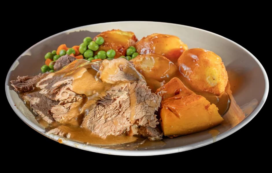 Sliced roast beef with roast potatoes and pumpkin in gravy