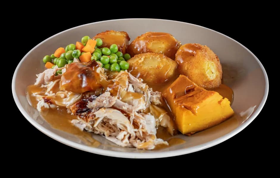 Roast chicken meal with roast potatoes, pumpkin, peas and carrots in gravy