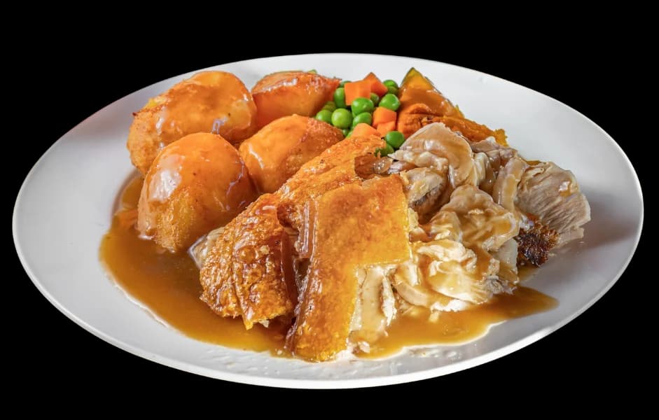 Roast pork meal with crackling, roast potatoes, pumpkin, peas and carrots in gravy